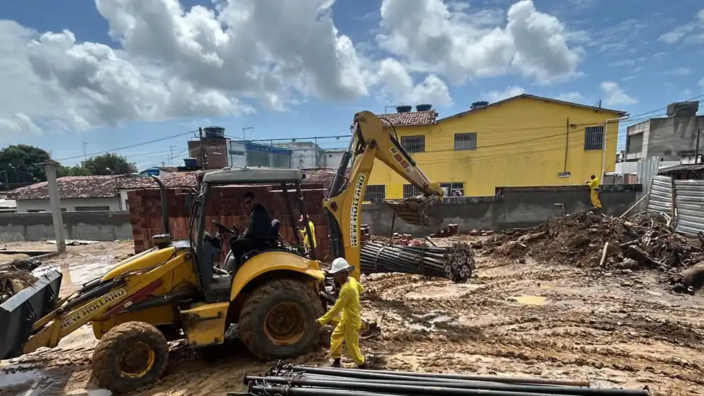 Descarga de escoras metálicas da SAF com retroescavadeira em obra em Igarassu